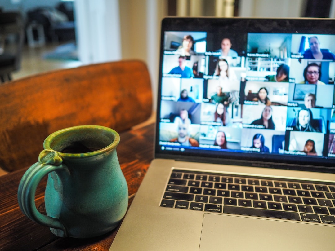 Zoom call with coffee by Virtual Personal Trainers macbook pro displaying group of people