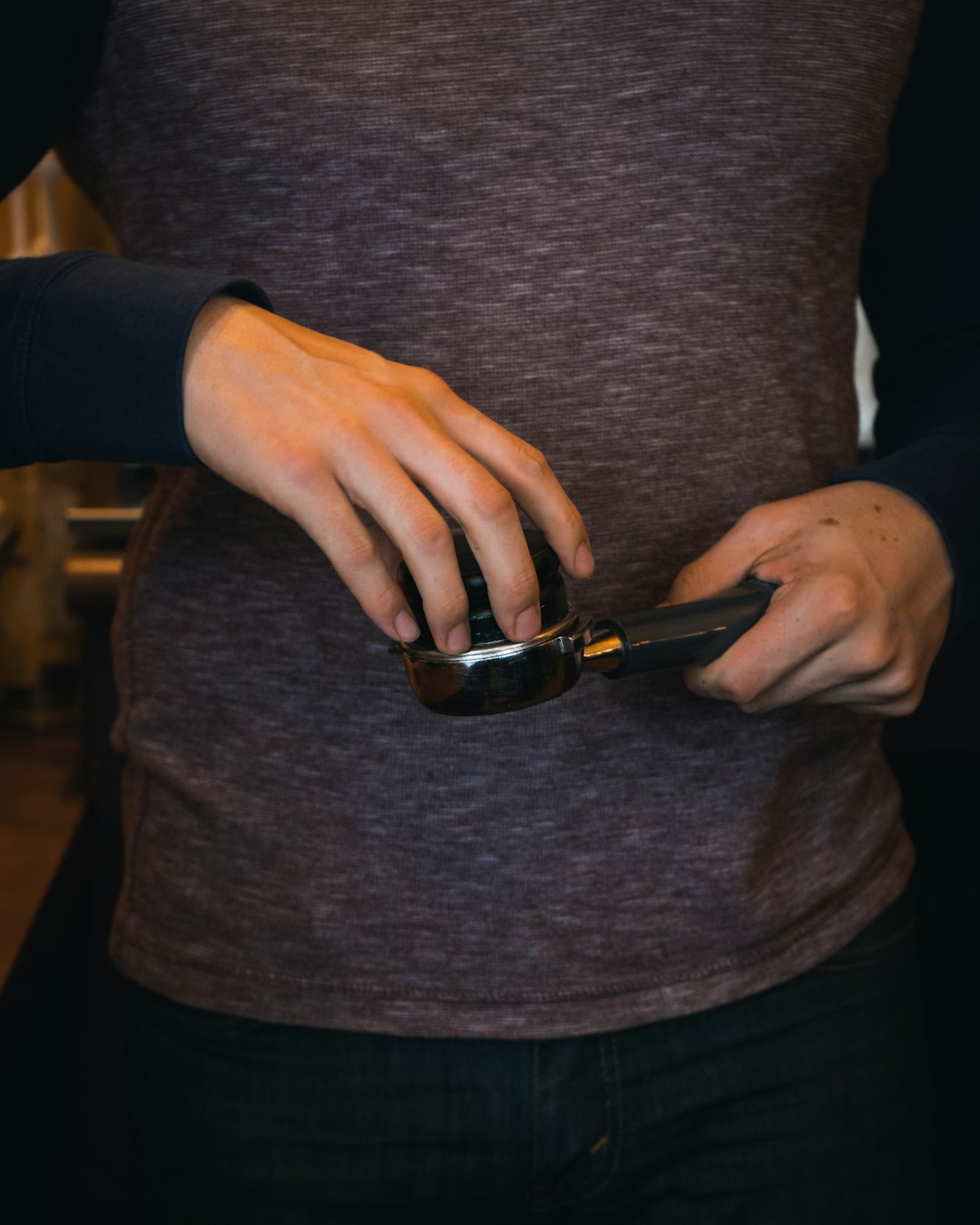 Tamping Coffee by Virtual Personal Trainers person in gray sweater holding black smartphone
