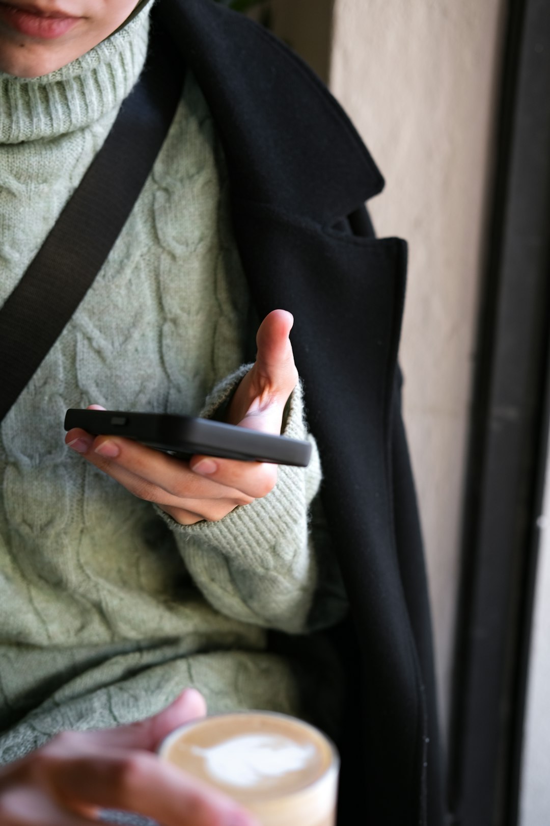 A woman holding coffee and phone by Virtual Personal Trainers a person holding a phone