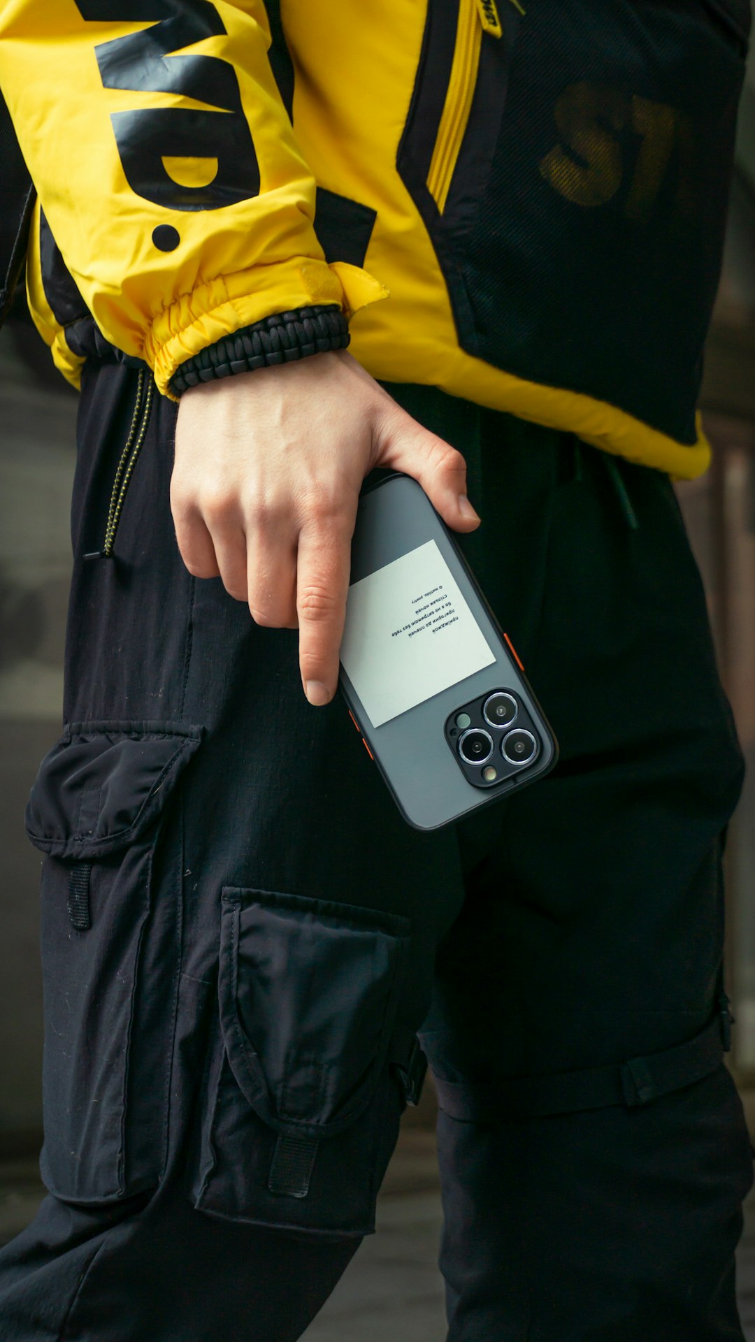 a person in a yellow jacket holding a cell phone